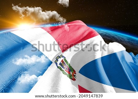 Dominican Republic national flag cloth fabric waving on beautiful sky.