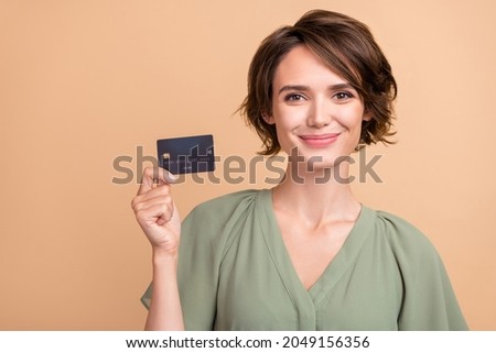 Photo of cheerful happy young woman smile hold hands credit card buy shop isolated on beige color background