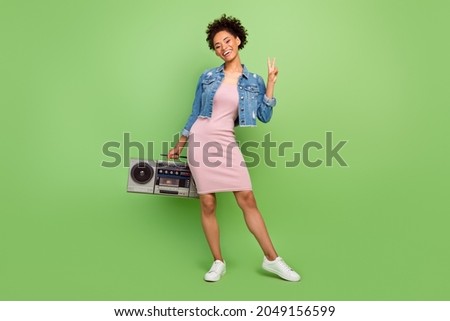 Full length photo of cute young lady with boom box show v-sign wear dress shirt sneakers isolated on green background