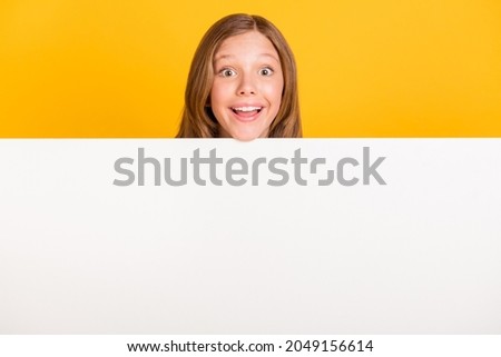 Photo of astonished cheerful pupil head above empty space wall toothy smile isolated on yellow color background