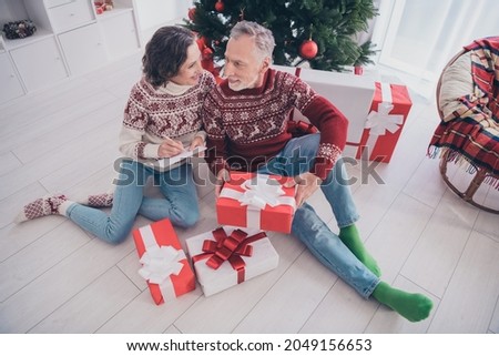 Full body photo of funny couple elder lady man sit with present wear sweater jeans socks at home
