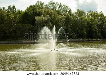 Fountain in the lake. Water pours from the pipes. Urban infrastructure. Splashes of water on the lake.