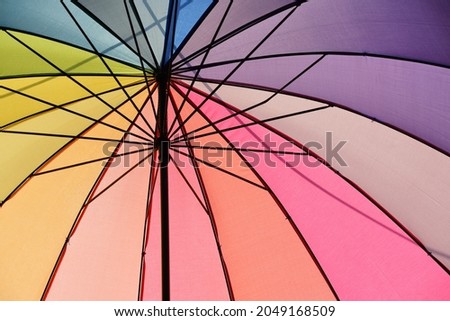 Close up of a colorful open umbrella in the colors of the rainbow