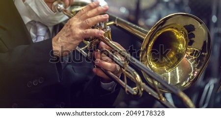 man playing the trombone. golden metal instrument detail. to use in banners or presentations Royalty-Free Stock Photo #2049178328