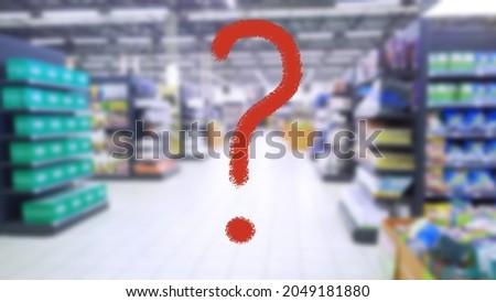 Large red question mark on abstract blur image of supermarket background. Defocused shelves with good and products. Grocery shopping. Store. Retail industry. Food. Rack. Inflation and problem concept