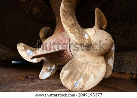 The bottom of a ship supported in dry dock with azimuth propulsion and twin propellers aft. Royalty-Free Stock Photo #2049195377