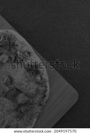 Composition of close up of fresh black and white pizza on gray background. food menu and template concept digitally generated image.