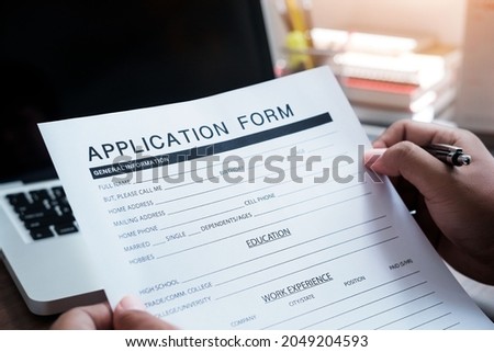 Online Web Job Application Form Concept. Close-up of unrecognizable businessman sitting at table with making notes in application form
