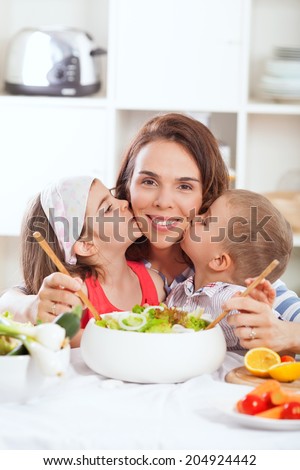 Kids kissing mother in kitchen
