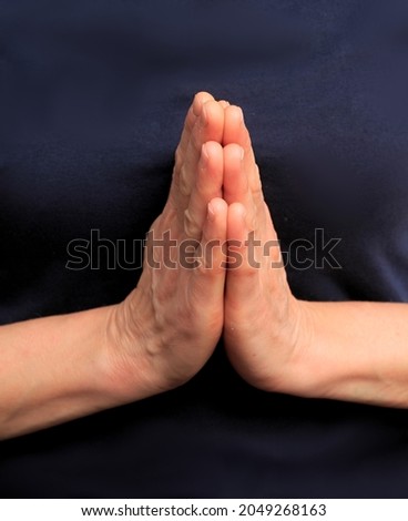 hands praying together on black background stock photo  