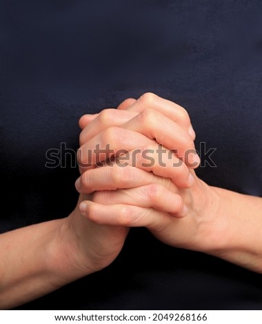 hands praying together on black background stock photo  