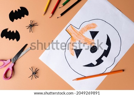 Halloween decoration with stationery on orange color background. Childrens craft for Halloween. DIY creative idea.
