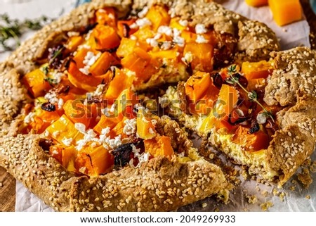 close-up of pumpkin galette with caramelized onion, cream cheese, thyme and crumbled feta cheese