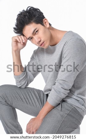 portrait of handsome young man model sitting cube posing in studio

