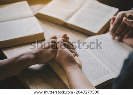 Group of christian people reading and study bible in home and pray together.Group of people holding hands praying worship god.Diverse religious shoot. Royalty-Free Stock Photo #2049279500