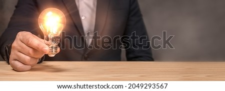 Smart thinking idea and inspiration innovation concept. Hand of holding illuminated light bulb, idea, innovation inspiration concept. Innovative idea in businessman hand. banner, copy space