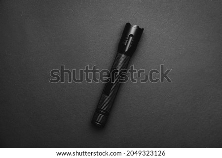 Modern flashlight on dark background