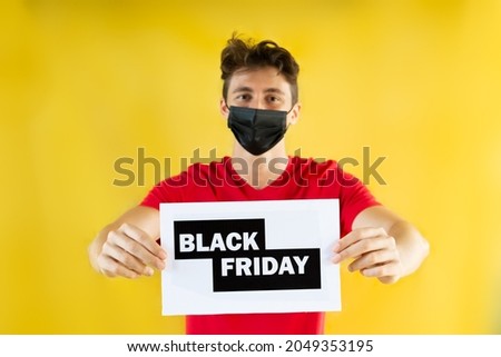 Teenager boy holding Black Friday  sale card. Special promo with yellow background.