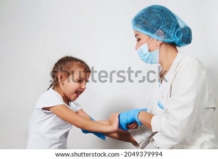 Female doctor injecting vaccine to girl. Young nurse doctor and child girl on white background with copy space, close-up