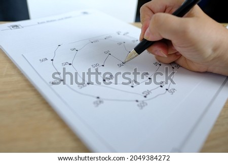close-up female hand draws lines on paper, connects dots by numbers, concept of brain development in old age, preventive measures in the fight against senile dementia, therapeutic health support Royalty-Free Stock Photo #2049384272
