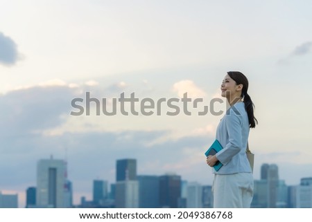 Young asian woman standing in front of the city. Royalty-Free Stock Photo #2049386768