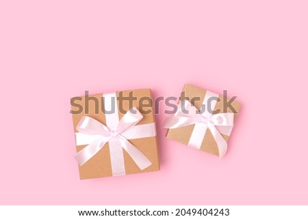 Gift boxes on a pink background. Present tied with ribbon. Festive concept with copyspace.