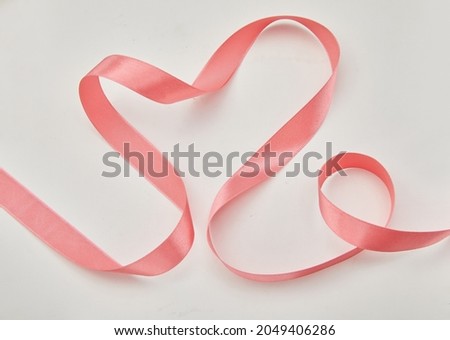 Pink heart ribbon isolated on white background