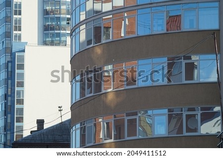 Horizontal full-color photo. Urban texture. Glass and concrete with reflections in the evening light.