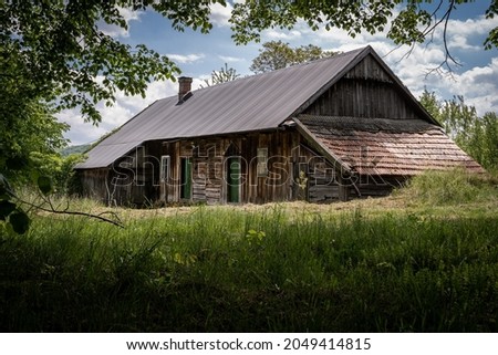 An old wooden house in the countryside. Idyll, meadow, village, abandoned house Royalty-Free Stock Photo #2049414815