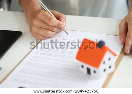 Woman signs home purchase agreement in office closeup