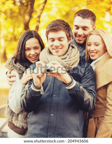 summer, holidays, vacation, travel, tourism, happy people concept - group of friends or couples having fun with photo camera in autumn park