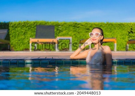 Portrait beautiful young asian woman relax smile leisure around outdoor swimming pool in hotel resort