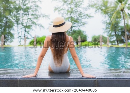 Portrait beautiful young asian woman relax smile leisure around outdoor swimming pool in hotel resort nearly sea beach
