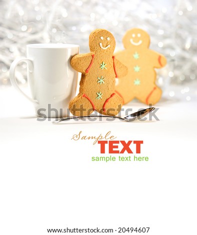 Hot holiday drink with gingerbread cookies on festive background