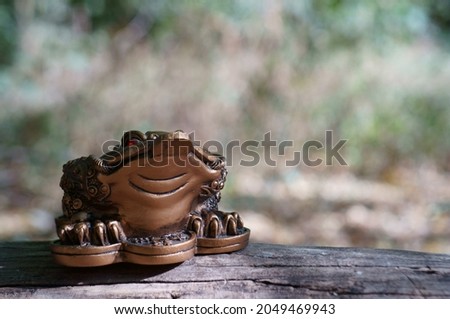 Metal toad on a wooden surface.