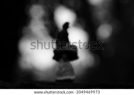 Blurred background. A figure of a dwarf in a festive hat on a dark background.