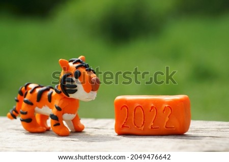 A tiger figurine made of plasticine. Next to the number 2022.