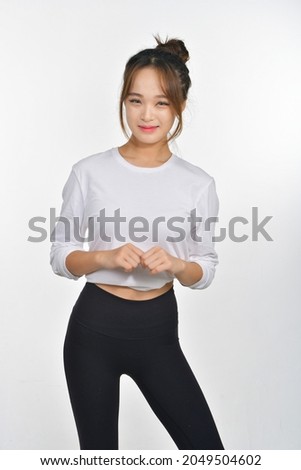 A beautiful Korean woman wearing black pants and a white top