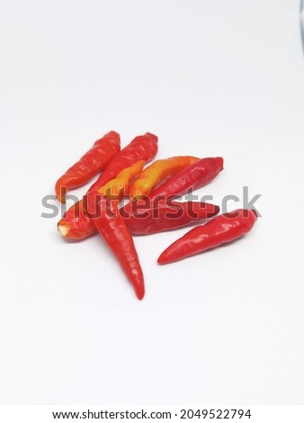 Blurry and noise picture of some spicy red cayenne pepper on a white background