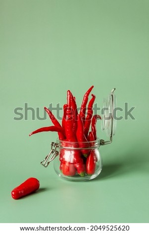 red chili peppers in a glass jar, conservation concept.