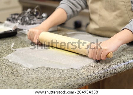 dough being flattened by rolling pin