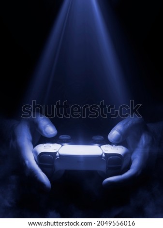 Man holding game controller with spot light and fog Royalty-Free Stock Photo #2049556016