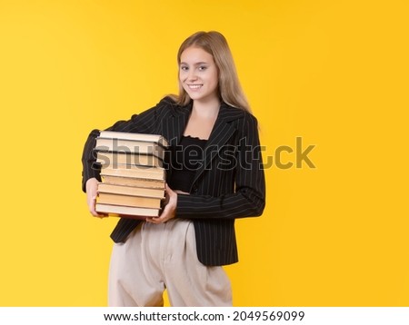 Happy teenagers. Teenagers with books in their hands. Happy teenagers looking at camera. student in casual jacket. Girl on yellow background. Concept - college preparation. Young woman with books