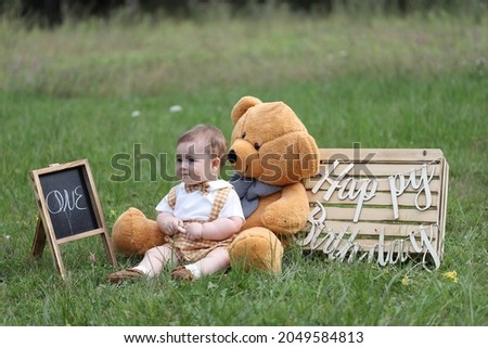 cute little boy playing with balloons and toys in the garden