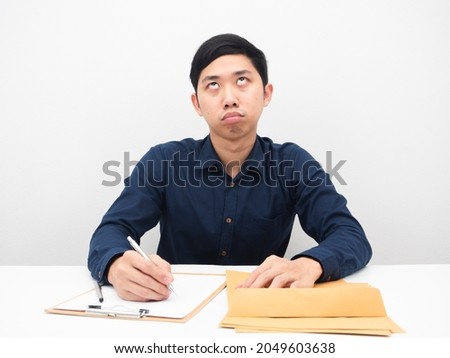 Man sitting at workplace feeling bored with document looking up white background