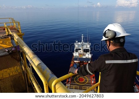 Worker watch Cargo being loaded from oil and gas platform onto a supply vessel Royalty-Free Stock Photo #2049627803