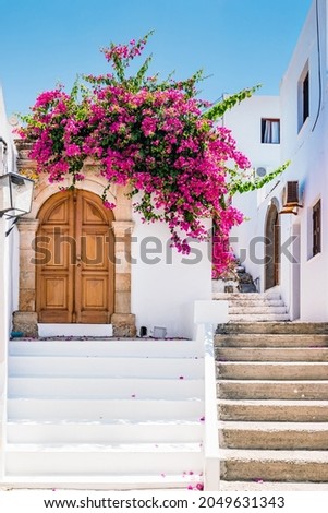 White buildings with bougainvillea flowers in Lindos on Rhodes island, Greece. Royalty-Free Stock Photo #2049631343