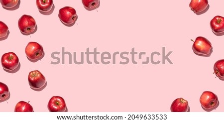 Red apples on pink background. Pattern, top view, flat lay, copy space.