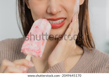 Health asian young woman touching cheek, expression, suffering from toothache, decay or sensitivity cavity molar tooth, teeth or inflammation eat cold ice cream at home. Sensitive teeth people. Royalty-Free Stock Photo #2049645170