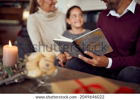 Close-up of Jewish family reading Tanakh  while celebrating Hanukkah at home. Royalty-Free Stock Photo #2049646022